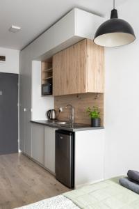 a kitchen with white and wooden cabinets and a sink at ADLER Studio in Łódź