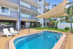 a swimming pool in front of a building at Style, Luxury and Comfort in Larrakeyah in Larrakeyah