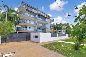 a white building with a fence in front of it at Style, Luxury and Comfort in Larrakeyah in Larrakeyah