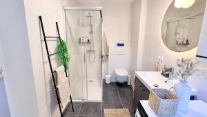 a white bathroom with a shower and a sink at M8 ParkSide Studio One in Graz
