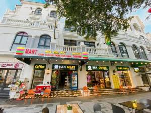 a large white building with shops on a street at B&K Homestay - Glocery Store in Phu Quoc