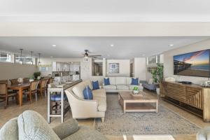 ein Wohnzimmer mit Sofa und Tisch in der Unterkunft Hawaiian Style Beachfront on Beach Road in Capistrano Beach