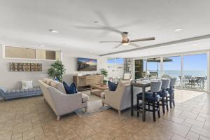 ein Wohnzimmer mit Tisch und Stühlen und dem Meer in der Unterkunft Hawaiian Style Beachfront on Beach Road in Capistrano Beach