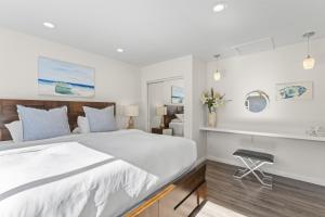 a bedroom with a large white bed and a chair at Hideaway ALL Walk to the Beach Downtown AC in San Clemente