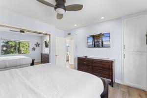 ein weißes Schlafzimmer mit einem Bett und einem Deckenventilator in der Unterkunft Hideaway B Walk to the beach Downtown AC in San Clemente