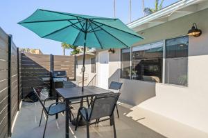 ein Tisch und Stühle mit einem grünen Sonnenschirm auf einem Balkon in der Unterkunft Hideaway B Walk to the beach Downtown AC in San Clemente