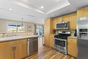 a kitchen with stainless steel appliances and wooden cabinets at Bright 3BR Beach Condo Near Casino and Ole Hanson in San Clemente