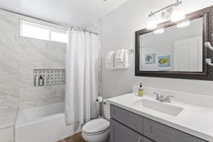 a white bathroom with a sink and a toilet at Bright 3BR Beach Condo Near Casino and Ole Hanson in San Clemente +34 photos