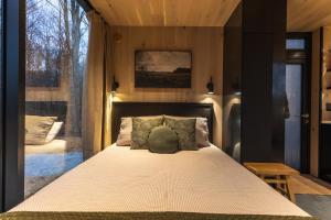 a bedroom with a bed and a large window at The Illusion Hideaway in New Plymouth