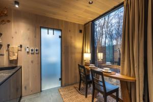 a kitchen with a table and chairs and a large window at The Illusion Hideaway in New Plymouth