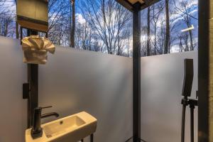 a bathroom with a sink and a window with trees at The Illusion Hideaway in New Plymouth +40 photos
