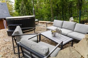a patio with two couches and a table with at Chata pod Prašivou in Vyšní Lhoty +2 photos