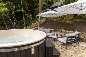 a hot tub with a table and chairs and umbrellas at Chata pod Prašivou in Vyšní Lhoty