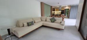 a living room with a white couch with pillows at Casa Amaré - Moreré in Moreré +14 photos