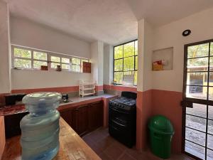 a kitchen with a table and a stove and windows at Casa Atitlán in Panajachel