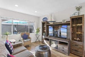 ein Wohnzimmer mit Fernseher und Sofa in der Unterkunft Hideaway C Walk to the beach Downtown AC in San Clemente