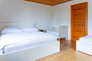 a bedroom with two beds and a wooden door at Chata pod Prašivou in Vyšní Lhoty