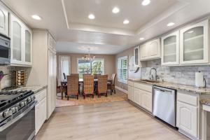 a kitchen with white cabinets and a dining room at 4BR Beach Condo Kids Hideaway Walk to Beach Casino Ole Hanson in San Clemente
