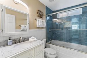 a bathroom with a sink and a toilet and a mirror at 4BR Beach Condo Kids Hideaway Walk to Beach Casino Ole Hanson in San Clemente +44 photos