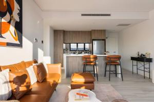 Waterfront Apartment in the Heart of Gosford في جوسفورد: غرفة معيشة مع أريكة ومطبخ