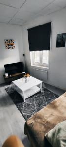 a living room with a white table and a window at Charmant deux pièces centre Cantimpré3 in Cambrai