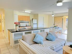 a living room with a couch and a kitchen at Riverview Modern Haven in Riverview
