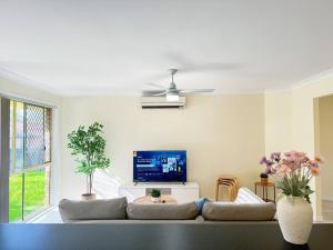 a living room with a couch and a flat screen tv at Riverview Modern Haven in Riverview