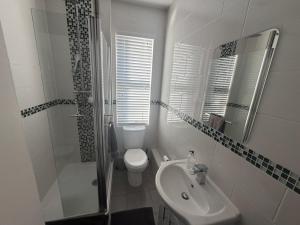 ein weißes Badezimmer mit Toilette und Waschbecken in der Unterkunft Cozy and Convenient Raynes Park maisonette in Raynes Park