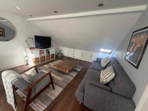 ein Wohnzimmer mit Sofa und Tisch in der Unterkunft Cozy and Convenient Raynes Park maisonette in Raynes Park