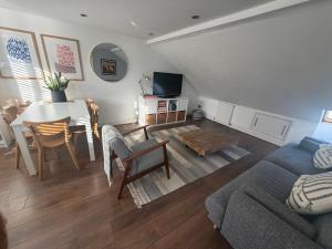 ein Wohnzimmer mit einem Sofa und einem Esstisch in der Unterkunft Cozy and Convenient Raynes Park maisonette in Raynes Park