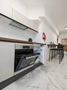 a kitchen with an open oven with a table and chairs at Balluta Bliss in St. Julianʼs