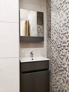 een badkamer met een wastafel en een spiegel bij Balluta Bliss in Il-Gżira