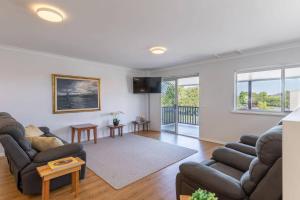 a living room with two couches and a tv at Central Chic- Beautifully appointed townhouse in Myrtleford