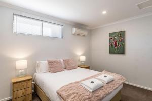 a bedroom with a bed with two pillows on it at Central Chic- Beautifully appointed townhouse in Myrtleford