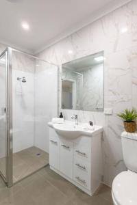 a white bathroom with a sink and a shower at Central Chic- Beautifully appointed townhouse in Myrtleford +27 photos