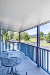 a patio with a table and chairs on a balcony at Central Chic- Beautifully appointed townhouse in Myrtleford