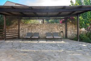 a group of chairs sitting under a stone wall at Vamos villa in Vamos +42 photos