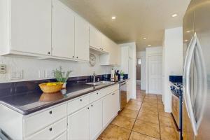 a kitchen with white cabinets and a refrigerator at Jewel of the Desert 259-342 in La Quinta +10 photos