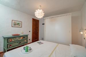 ein Schlafzimmer mit einem Bett und einem Kronleuchter in der Unterkunft VILLA PITRIZZINA 8, Emma Villas in Liscia di Vacca