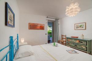 ein Schlafzimmer mit einem Bett, einem Tisch und einer Kommode in der Unterkunft VILLA PITRIZZINA 8, Emma Villas in Liscia di Vacca