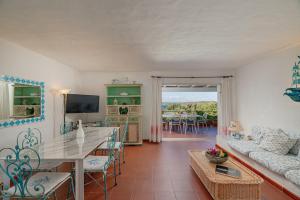 ein Wohnzimmer mit einem Tisch und einem Sofa in der Unterkunft VILLA PITRIZZINA 8, Emma Villas in Liscia di Vacca