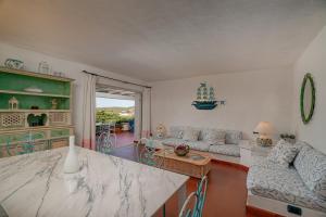 eine Küche und ein Wohnzimmer mit einem Tisch und einer Couch in der Unterkunft VILLA PITRIZZINA 8, Emma Villas in Liscia di Vacca + 42 Fotos