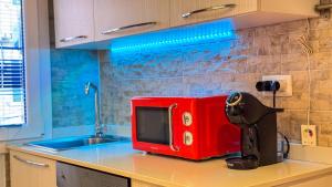 a red microwave sitting on top of a kitchen counter at La Casa Gialla by Ca-Sa Check in Chioggia