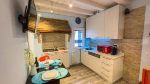 a small kitchen with white cabinets and a red microwave at La Casa Gialla by Ca-Sa Check in Chioggia