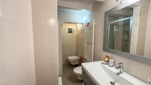 a bathroom with a sink and a toilet and a mirror at La Casa Gialla by Ca-Sa Check in Chioggia