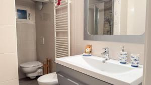 a bathroom with a sink and a toilet and a mirror at La Casa Gialla by Ca-Sa Check in Chioggia +17 photos