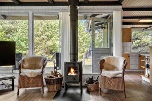 a living room with a stove and two chairs at 1344-Vestervig-Hedevej-43 in Vestervig