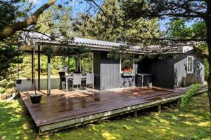 a wooden deck with a table and chairs on it at 1344-Vestervig-Hedevej-43 in Vestervig