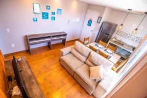 ein Wohnzimmer mit einer Couch und einem Klavier in der Unterkunft Confortável AP próximo ao parque e praias in Penha