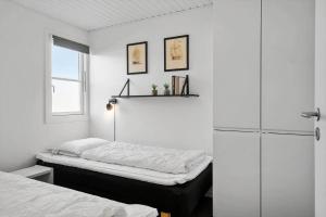 a white bedroom with a bed and a refrigerator at 1346-Vestervig-Havnevej-1-lejl-15 in Vestervig +24 photos